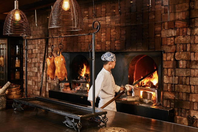 Where to Eat in Beijing: Open wood-fire kitchen at Country Kitchen, Rosewood Beijing, serving northern Chinese dishes like Peking duck and handmade noodles.