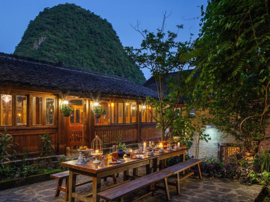 WildChina introduces the Best Boutique Hotels in China (2024) - The Secret Garden Boutique, with cozy nighttime dining and views of the karst mountains.
