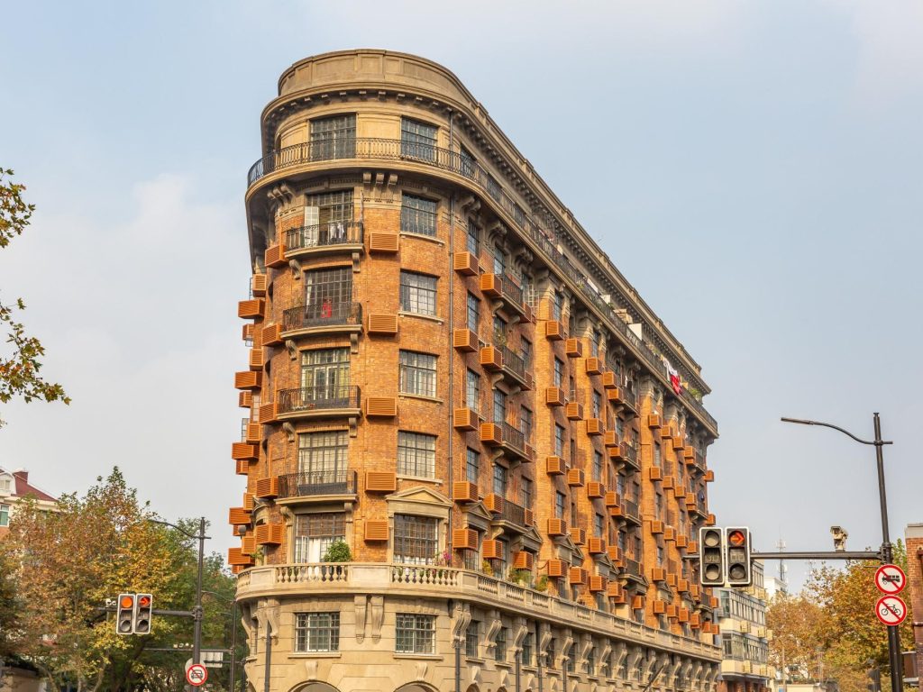 Where to Travel in China in Fall The iconic Wukang Mansion in Shanghai is framed by trees with fall colors.