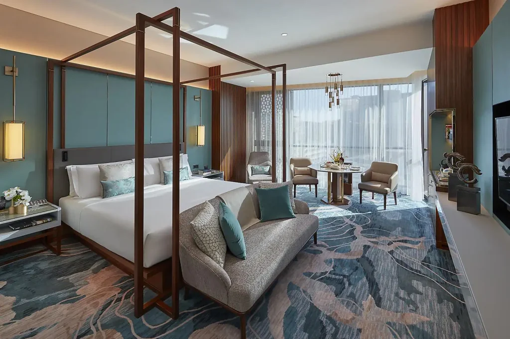 The Premier Suite features a four-poster bed adorned with plush, soft textiles